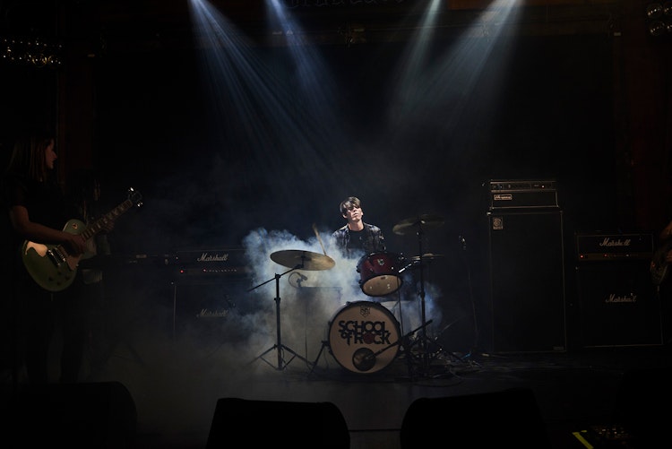 Advanced student learning to play the drums onstage